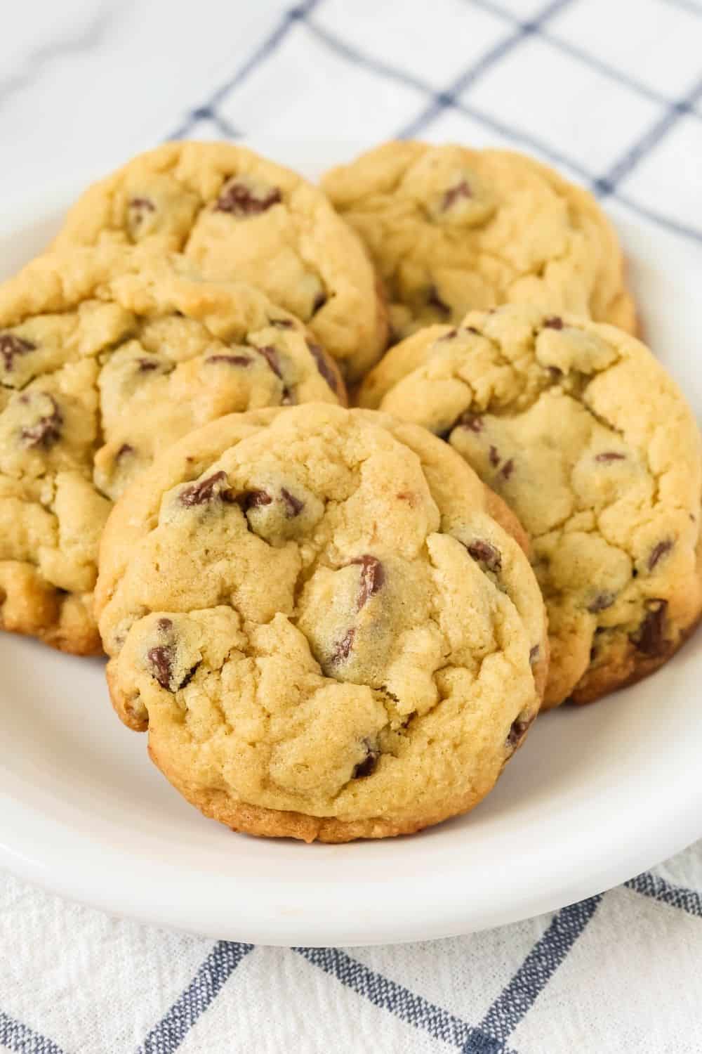 close-up of pudding mix chocolate chip cookies on a white plate, atop a blue and white checked napkin.