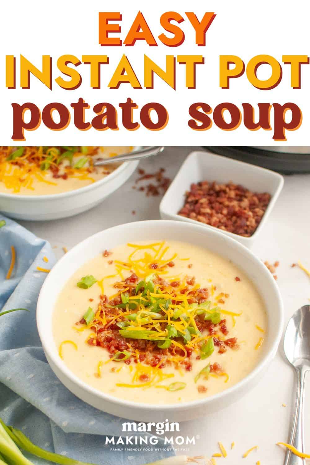 a white bowl of Instant Pot potato soup, garnished with shredded cheese, sliced green onions, and bacon bits.
