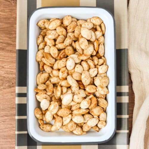 maple bourbon pumpkin seeds in a white serving dish.
