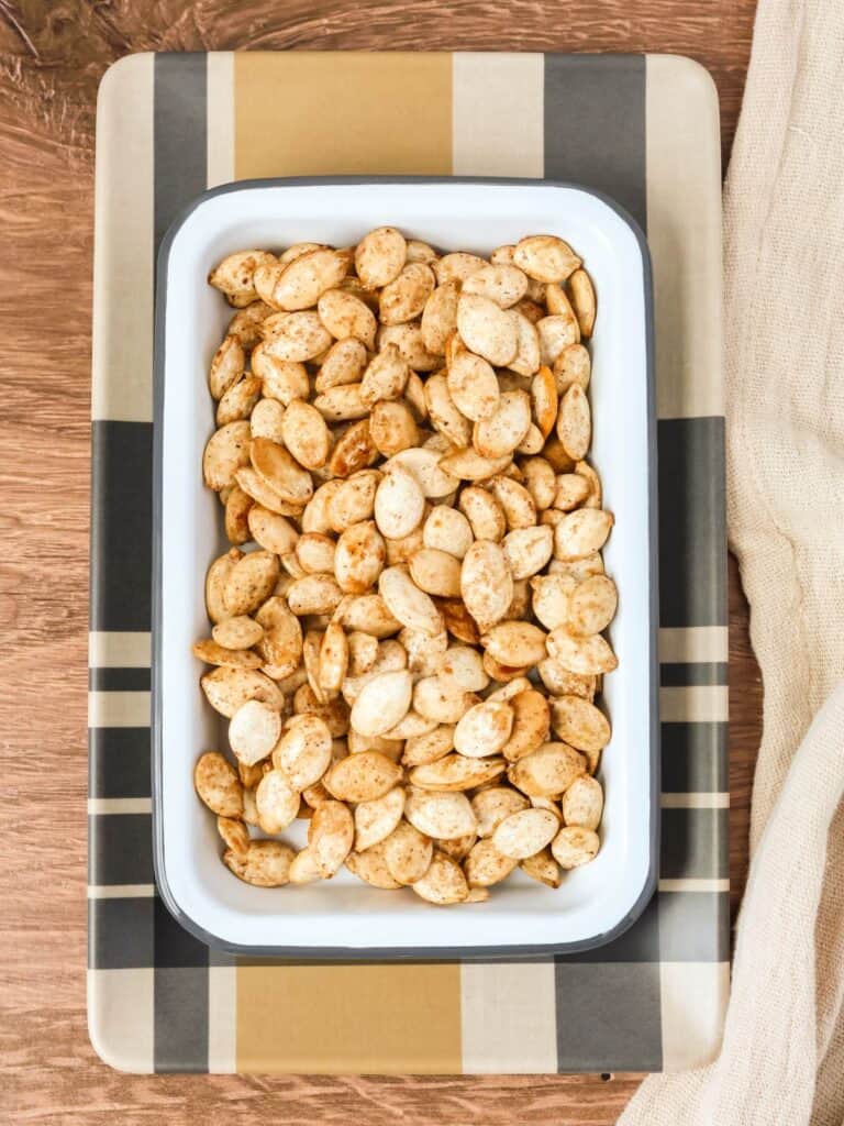 maple bourbon pumpkin seeds in a white serving dish.