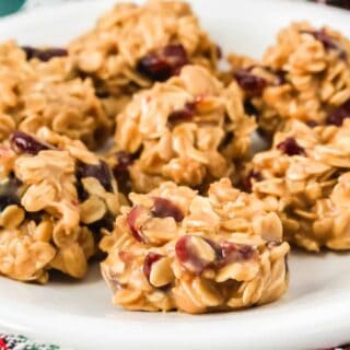 close-up view of no bake cranberry oatmeal cookies on a white plate, showing the detail of the chewy cookies dotted with dried cranberries.