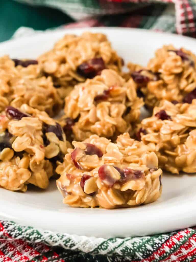 close-up view of no bake cranberry oatmeal cookies on a white plate, showing the detail of the chewy cookies dotted with dried cranberries.