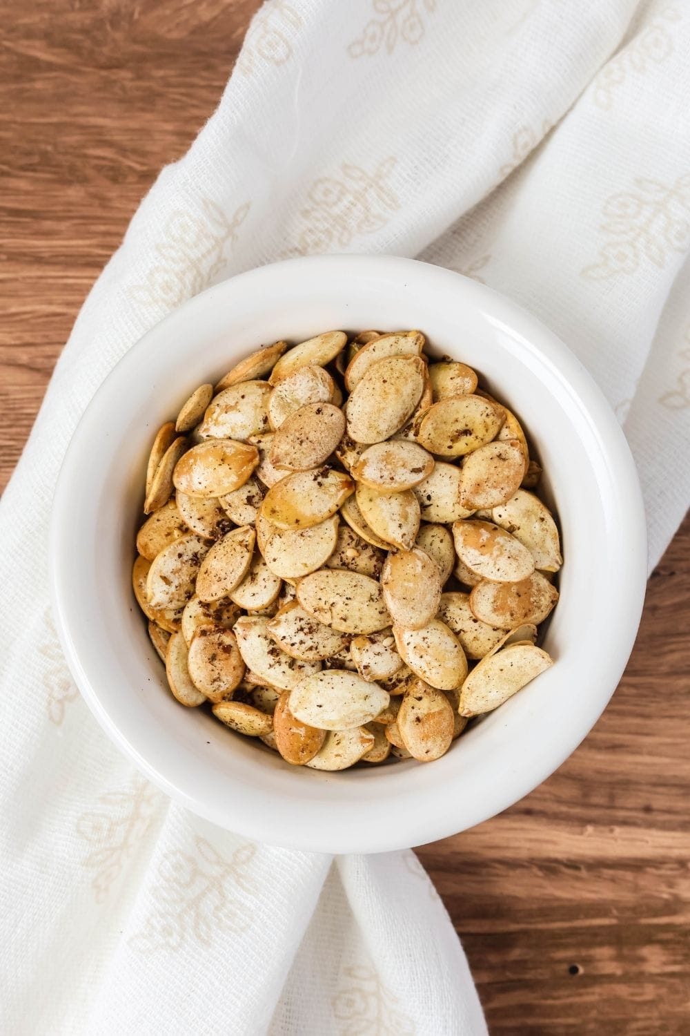 overhead view of a bowl of pumpkin seeds roasted with zaatar seasoning.