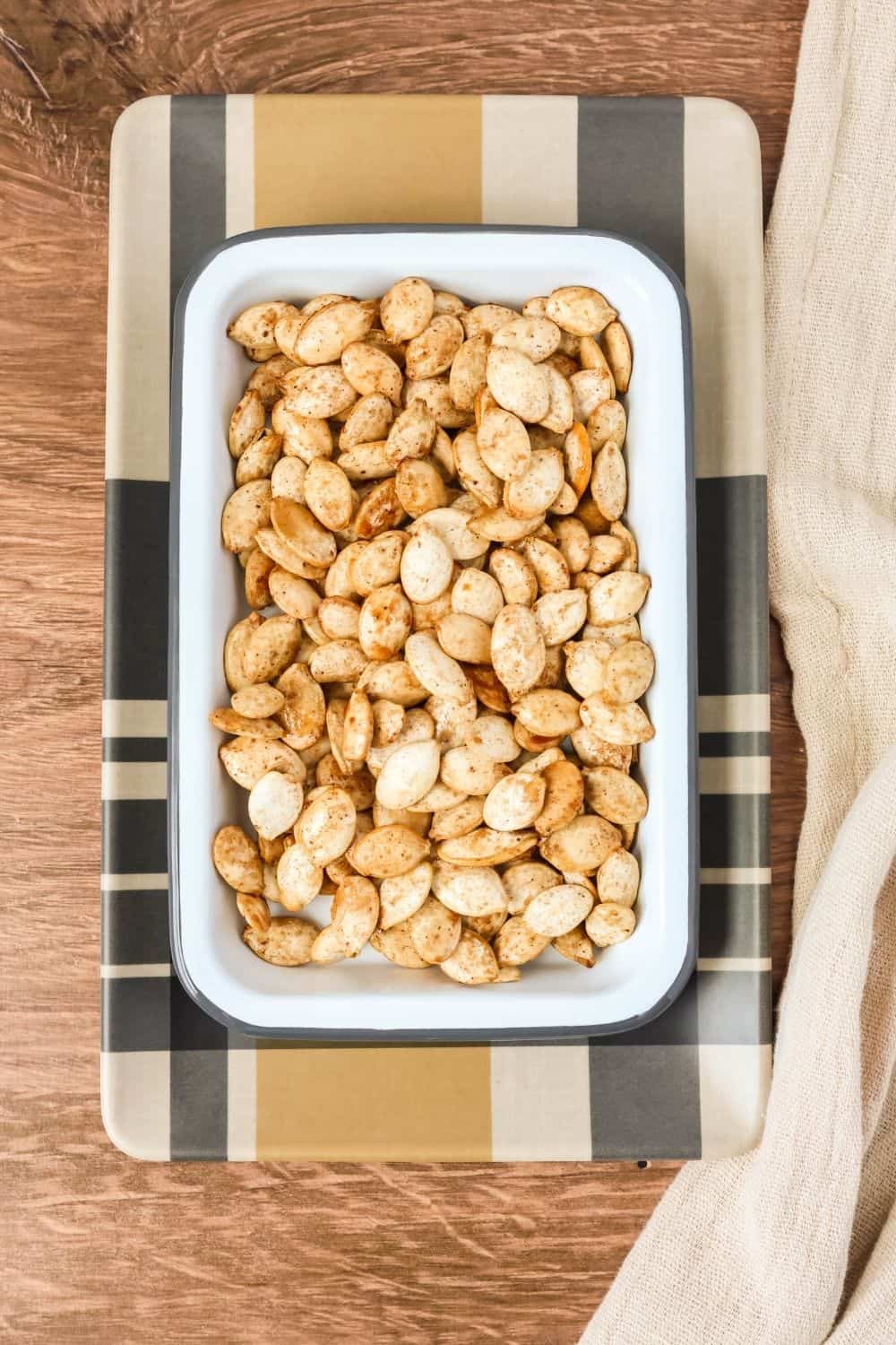 overhead view of a rectangular serving dish of pumpkin seeds that were roasted with bourbon and maple syrup.