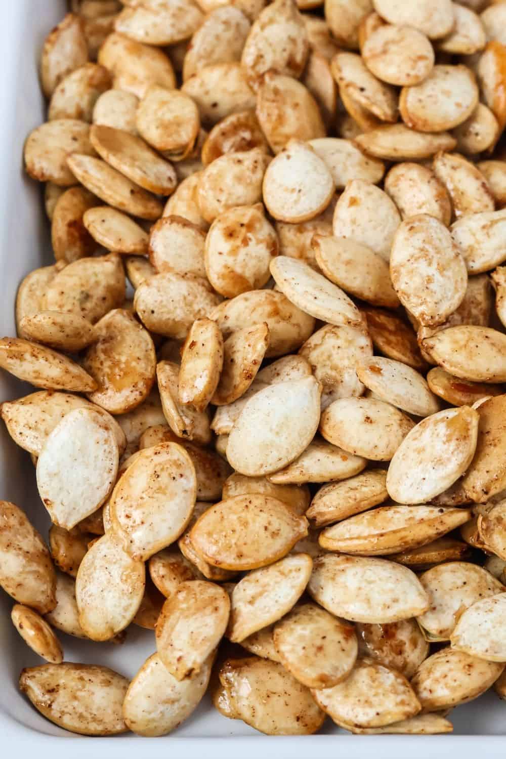 close-up view of bourbon roasted pumpkin seeds with maple syrup, showing how the maple syrup candies the seeds.