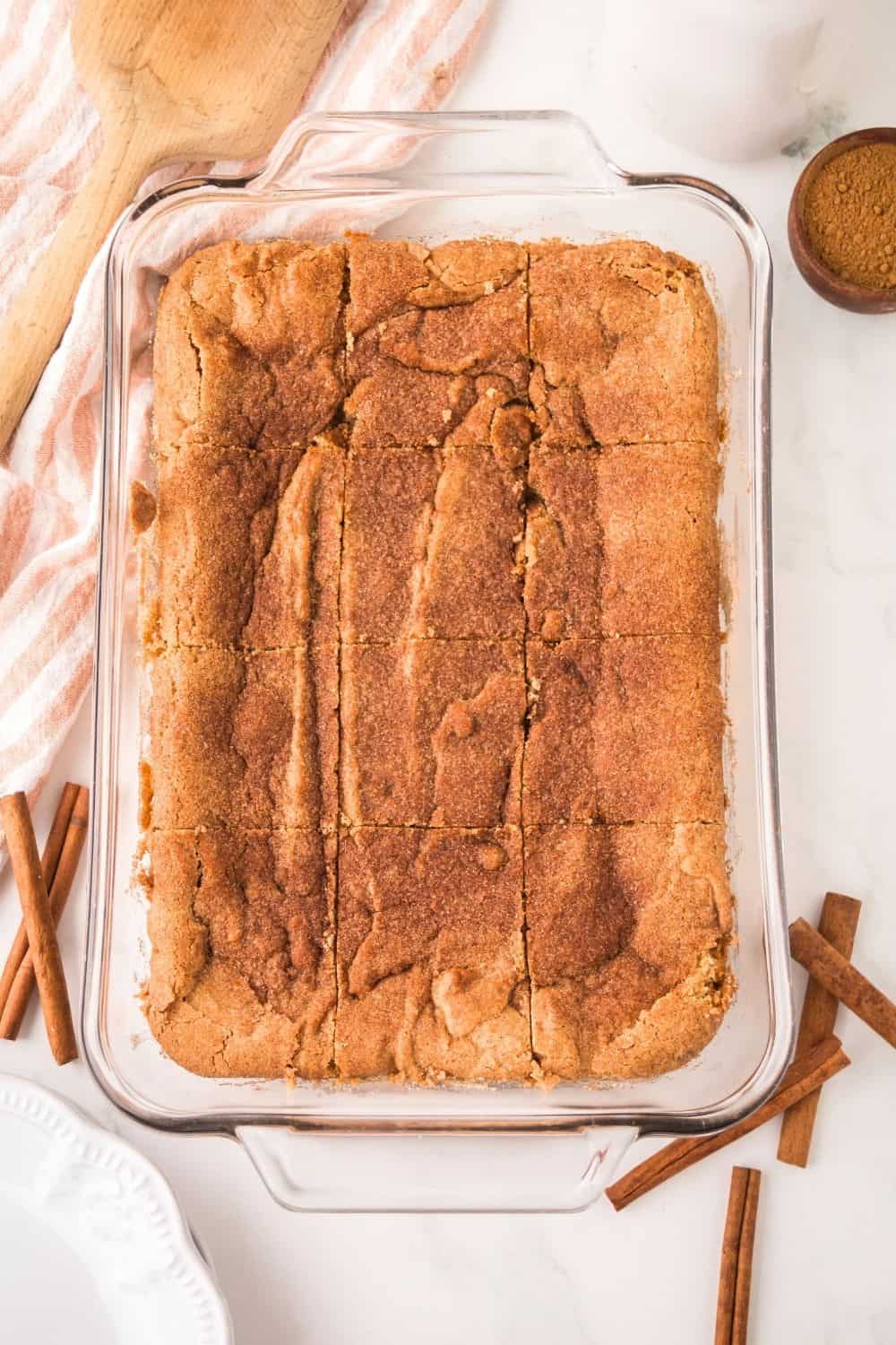 overhead view of a glass baking dish with sliced churro cookie bars in it.