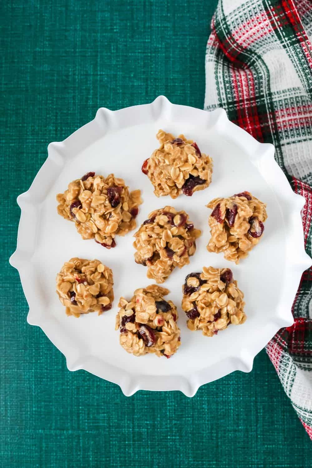 overhead view of a small white dessert stand serving no bake oatmeal cookies with craisins.