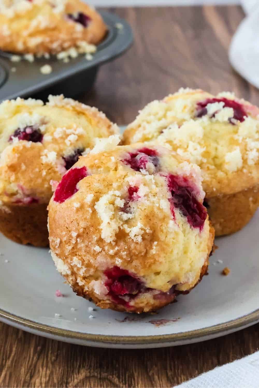 close-up view of the top of a holiday cranberry orange muffin, including the sugary streusel topping.