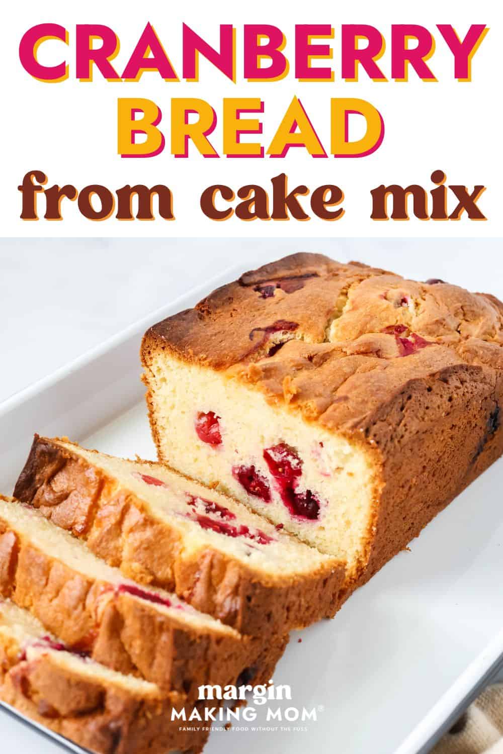 a partially-sliced loaf of cake mix cranberry bread on a white rectangular serving platter.