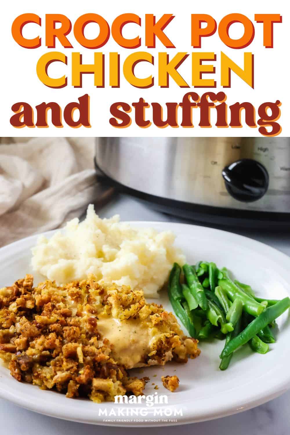 Crock Pot chicken and stuffing served on a white plate alongside green beans and mashed potatoes. A slow cooker is in the background.