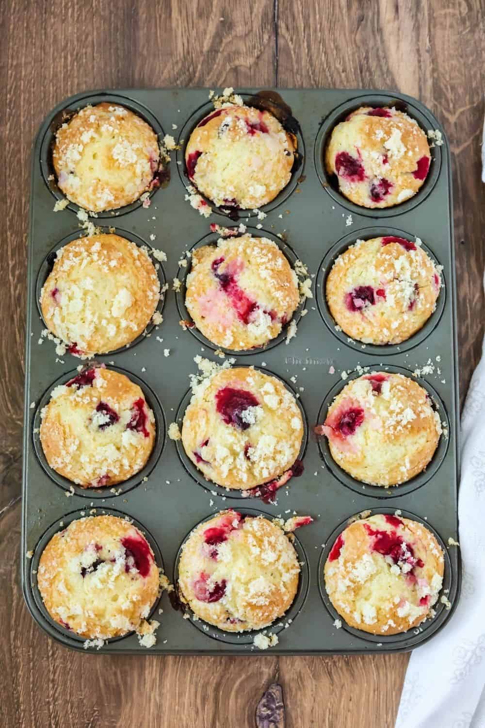 overhead view of a muffin tin with freshly-baked cranberry orange muffins for the holidays.
