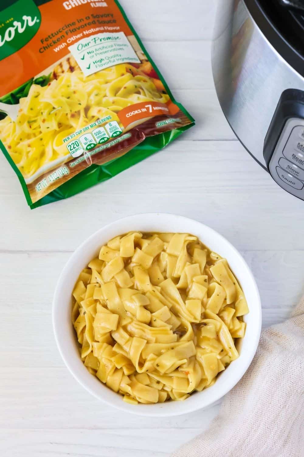 overhead view of a bowl of Knorr pasta sides chicken fettucine pasta alongside the pasta sides package and an Instant Pot.