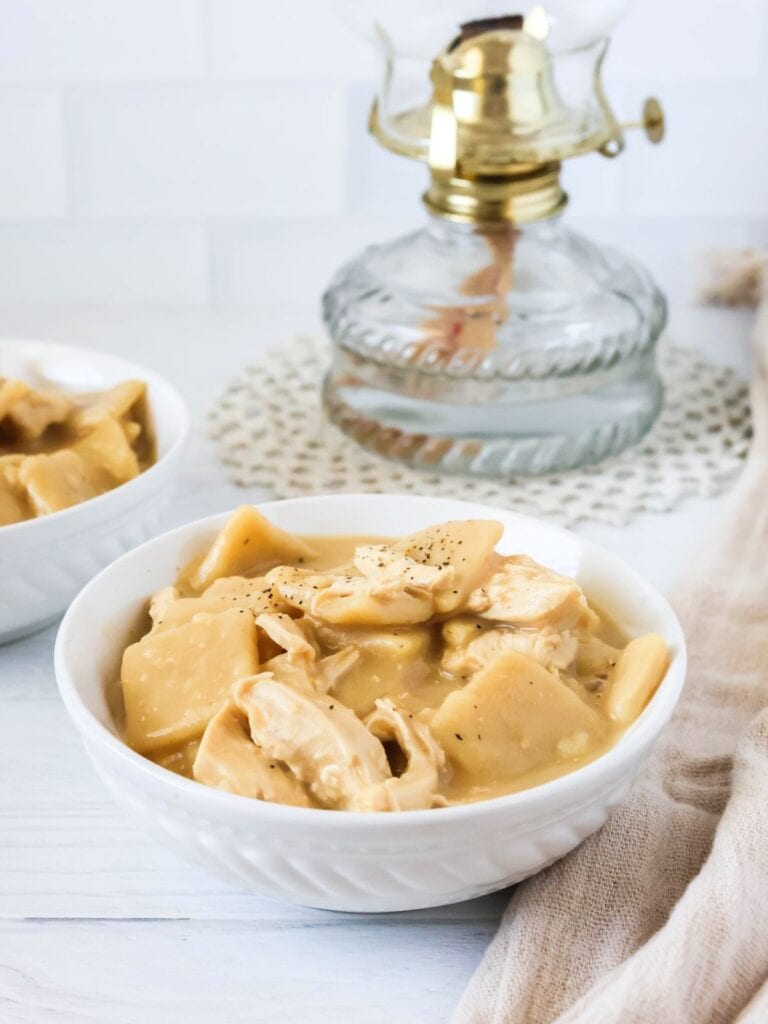 Instant Pot chicken and dumplings served in white bowls.