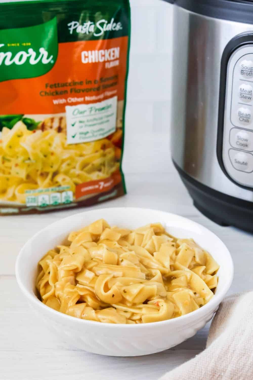 Knorr Pasta Side fettucine served in a white bowl, with the Pasta Sides package and an Instant Pot in the background.
