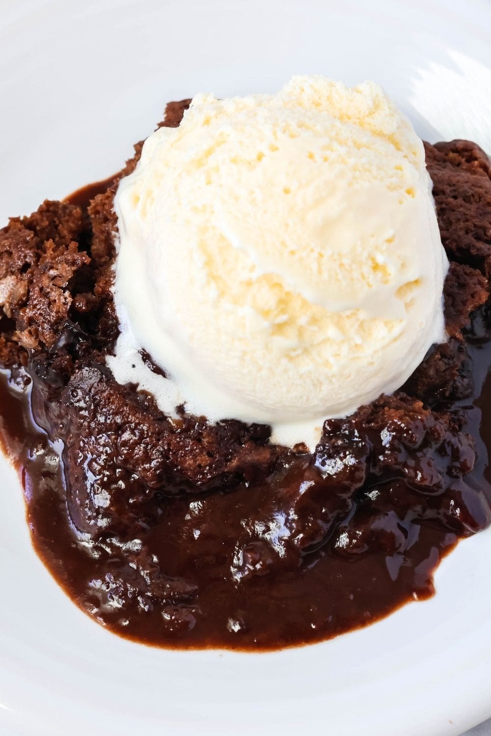 close-up view of Bisquick chocolate cobbler, which is like a lava cake of molten chocolate sauce and a cake-like top. It's served with ice cream.