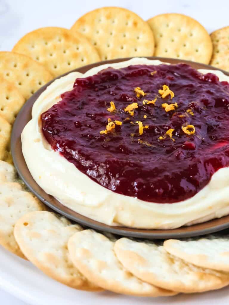 Close-up view of cranberry orange cream cheese dip surrounded by crackers.