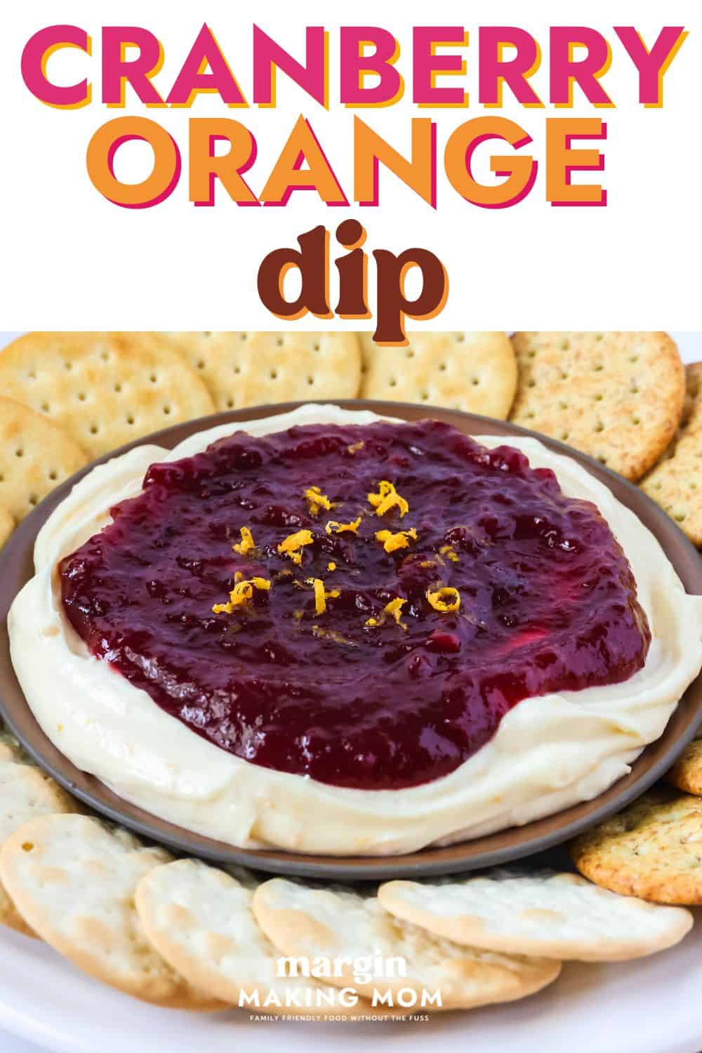 Cranberry orange cream cheese dip appetizer served on a plate alongside various types of crackers.