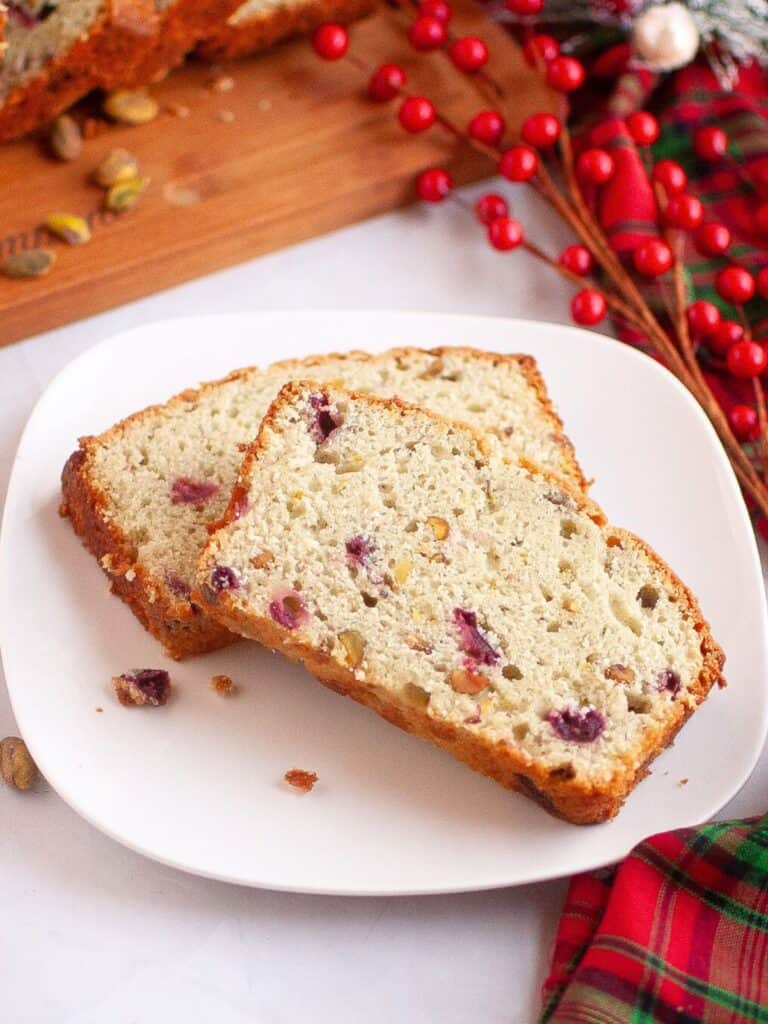 Cranberry pistachio bread slices served on a white plate.
