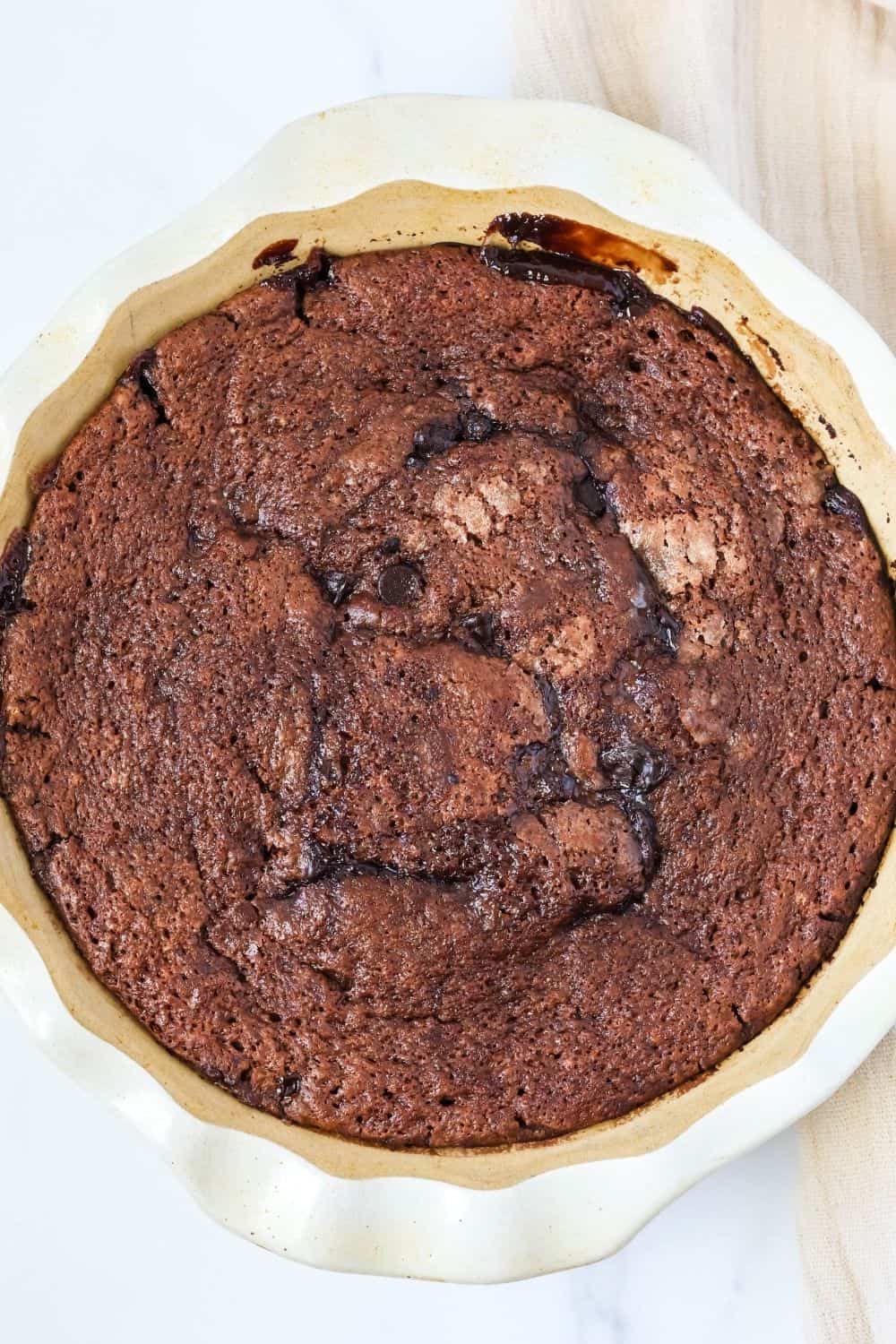 overhead view of freshly baked molten gooey chocolate cobbler in a deep dish pie pan.