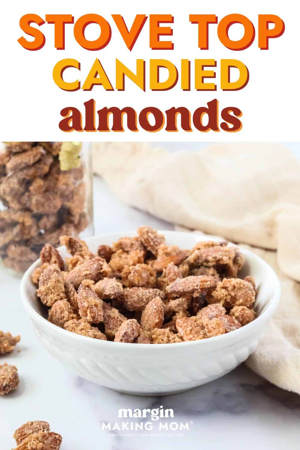 stove top candied almonds served in a white bowl. A jar of more cinnamon sugar almonds is in the background.