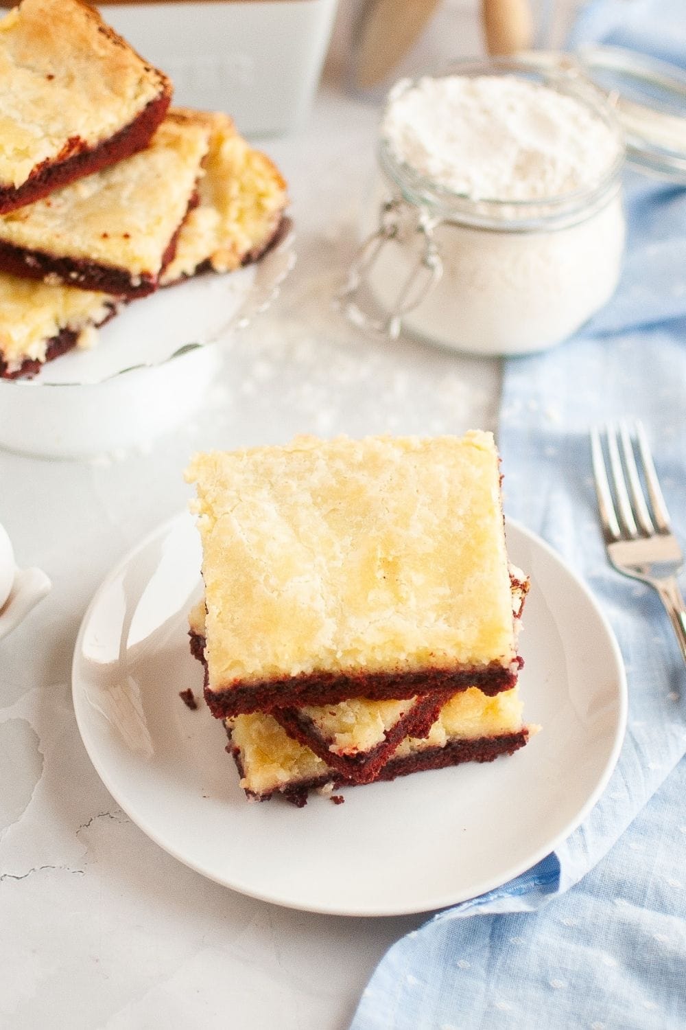 several red velvet ooey gooey bars stacked together.