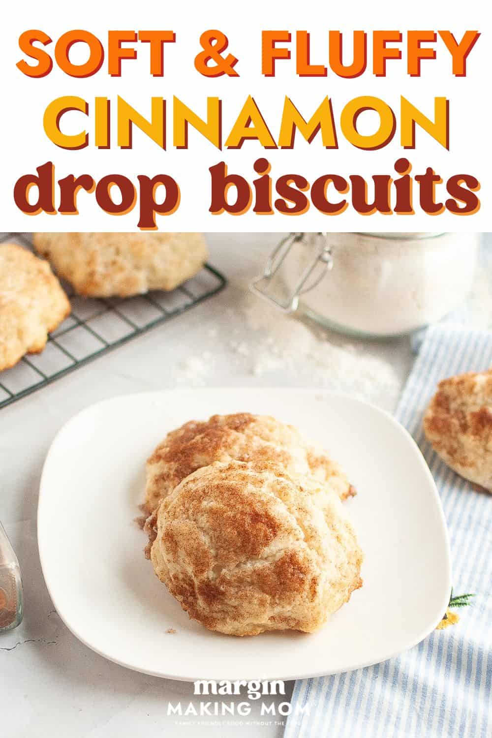 Two cinnamon sugar drop biscuits on a white plate, with more biscuits in the background.