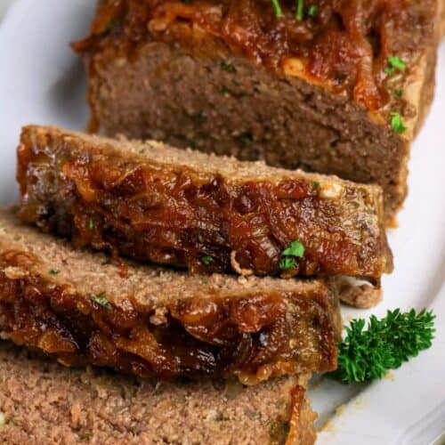 French onion soup meatloaf, partially sliced, served on a white platter.
