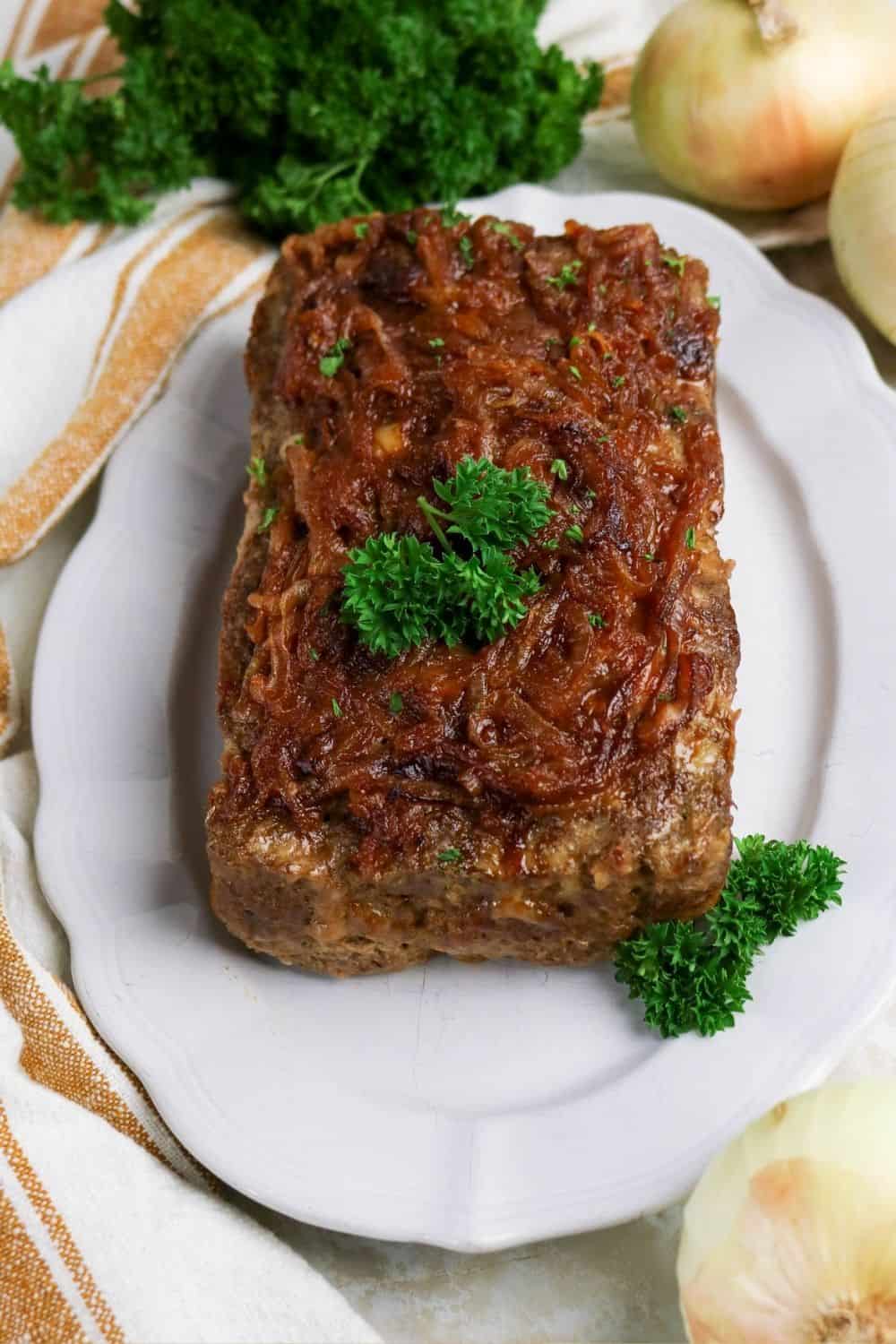 French onion soup meatloaf served on a white platter.