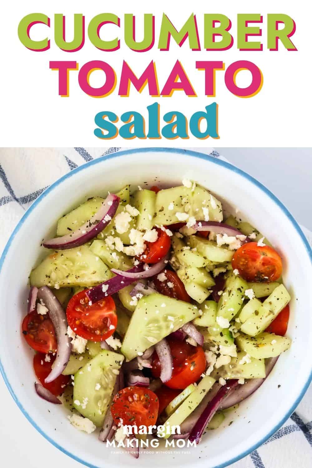 overhead view of a white and blue bowl of cucumber tomato salad.