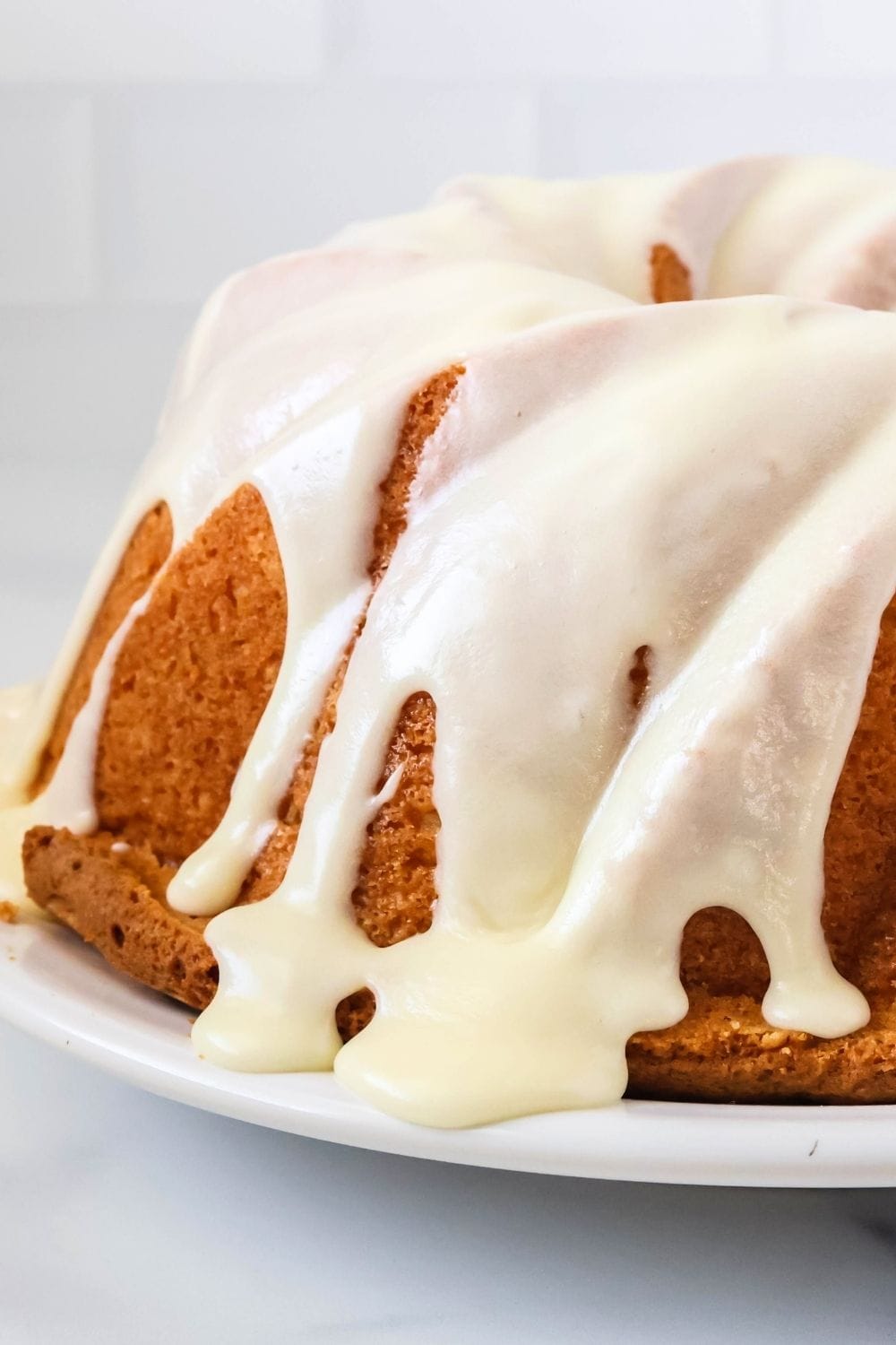 side view close-up of a coconut bundt cake drizzled with icing.