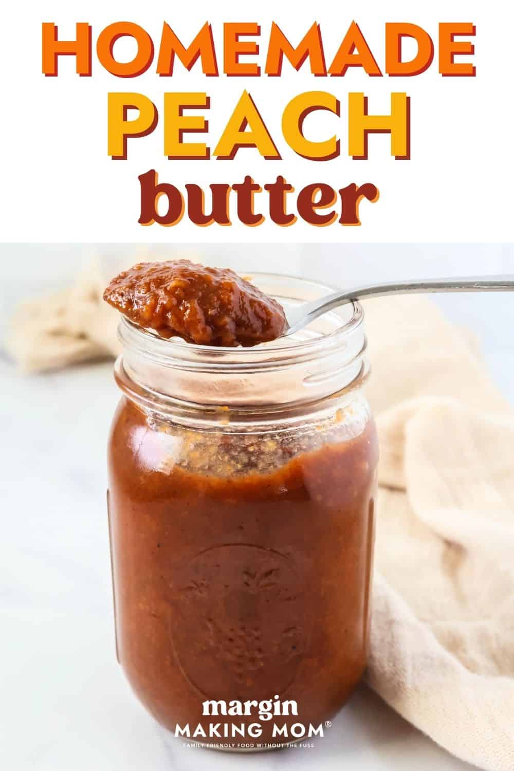 a mason jar of easy homemade peach butter, with a spoonful of peach fruit butter resting on the rim of the jar.