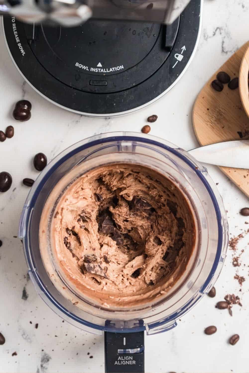 overhead view of coffee ice cream with chocolate chunks mixed in. The Ninja Creami machine is in the background.
