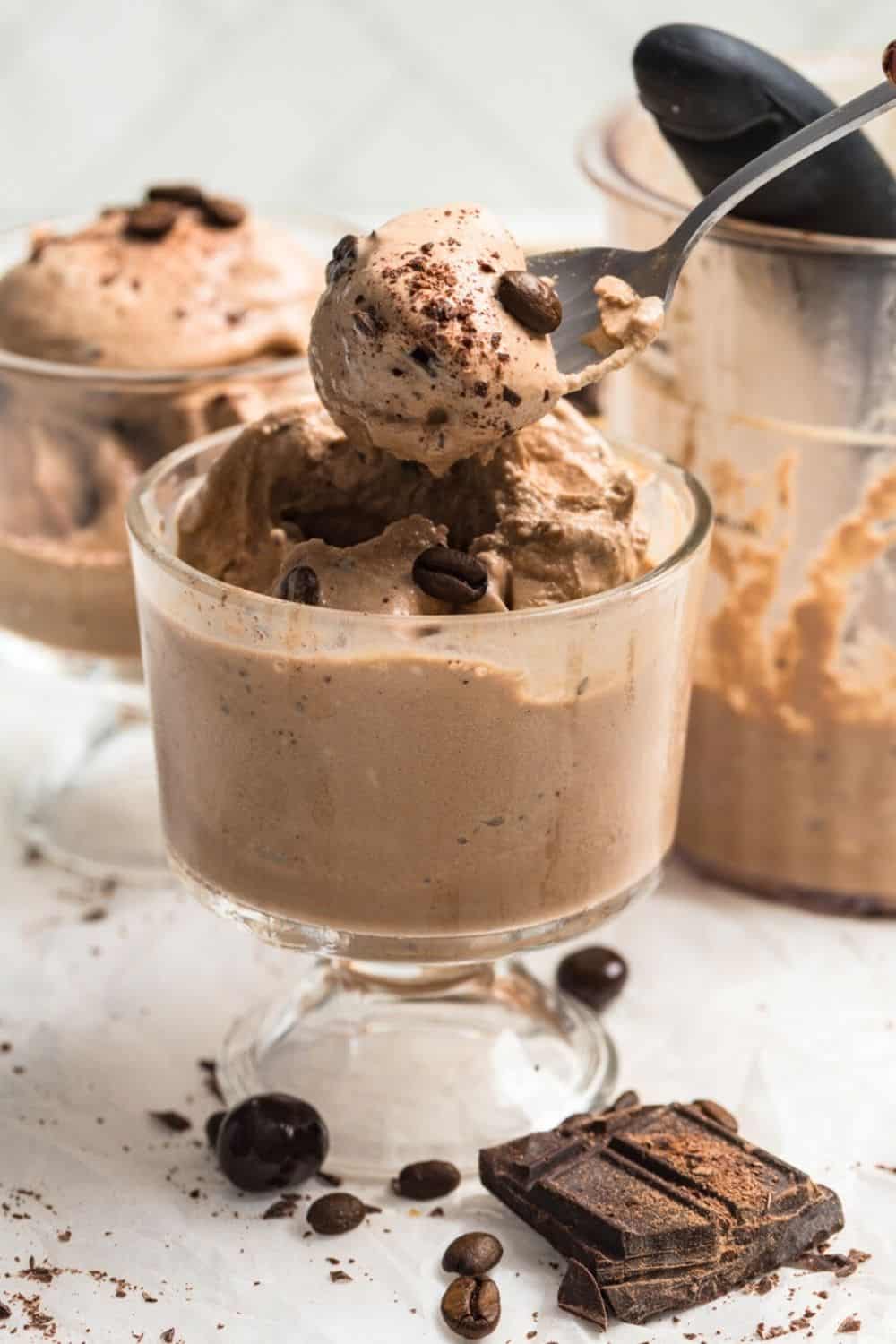 a spoon lifts out a bite of Ninja Creami mocha ice cream from a dessert cup.