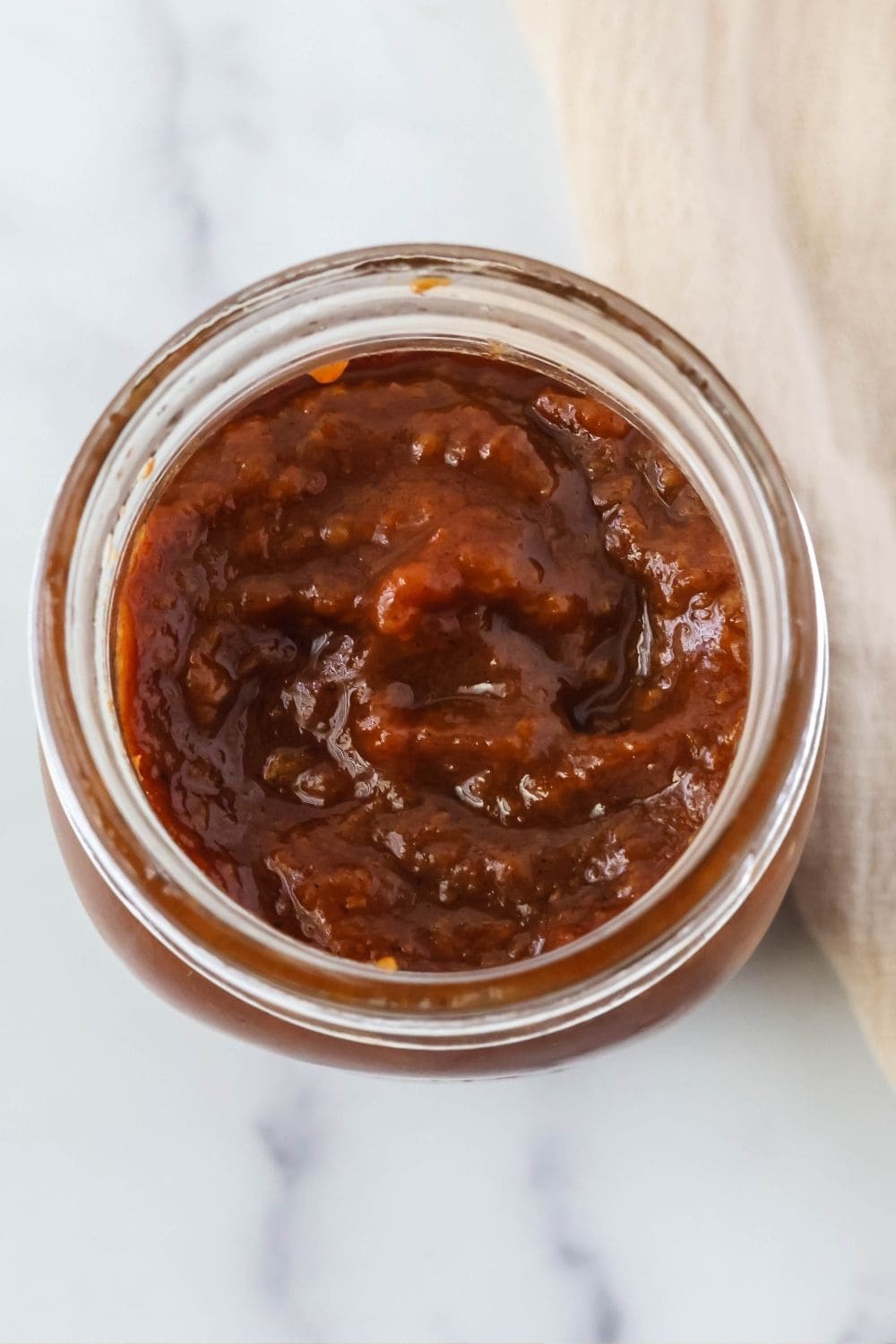 overhead view of the contents of a jar of spiced peach butter made in the slow cooker.