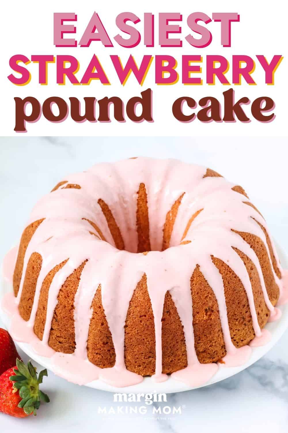 a strawberry pound cake, topped with strawberry glaze, is served on a white plate. Two fresh strawberries are next to the plate.