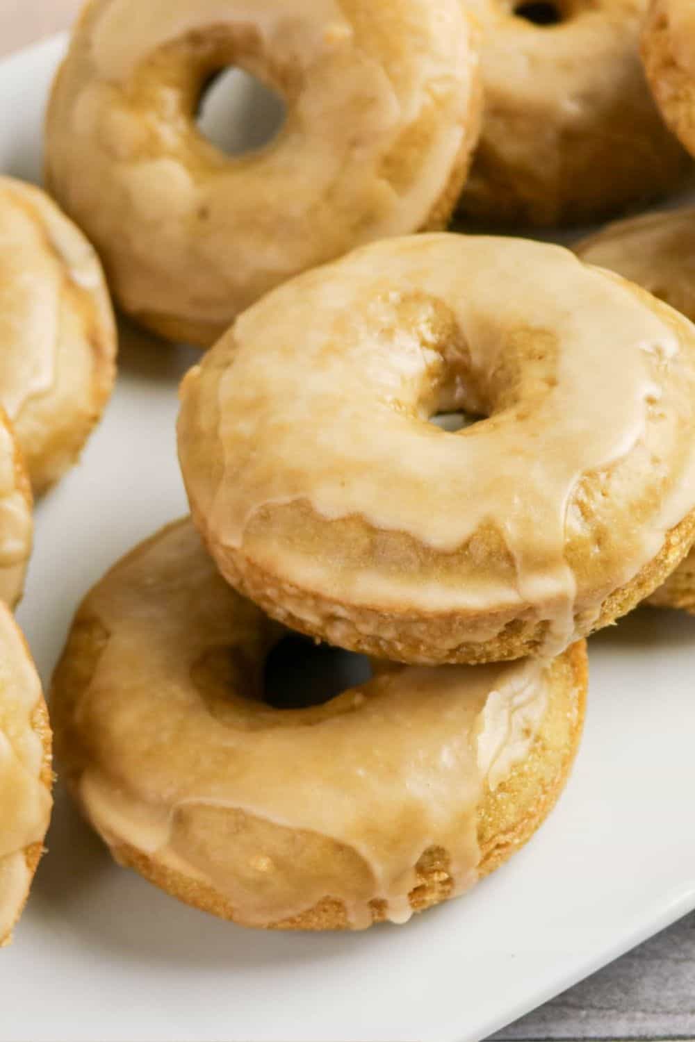 close-up view of coffee donuts made with Bisquick, topped with glaze and served on a white plate.