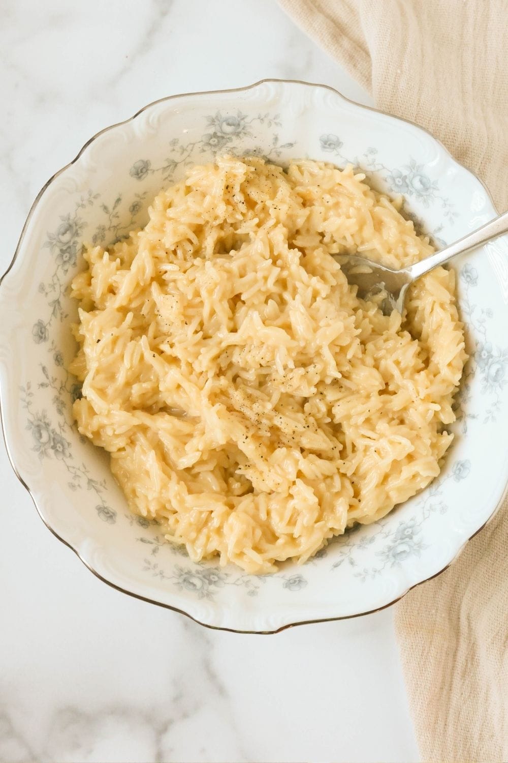 overhead view of a bowl of rice made with cream of chicken soup. A spoon is in the bowl, ready to scoop and serve.