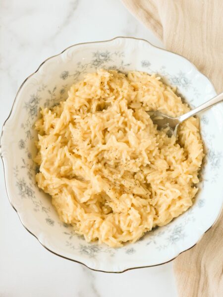 Souper rice served in a blue and white bowl, with a serving spoon in the bowl.