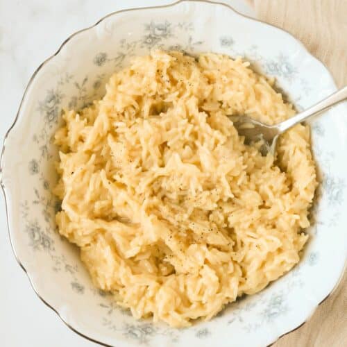 Souper rice served in a blue and white bowl, with a serving spoon in the bowl.