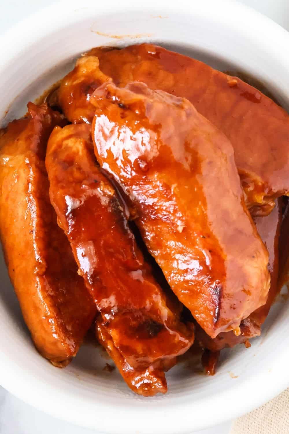 Overhead view of a white bowl filled with BBQ country style ribs cooked in the Instant Pot.