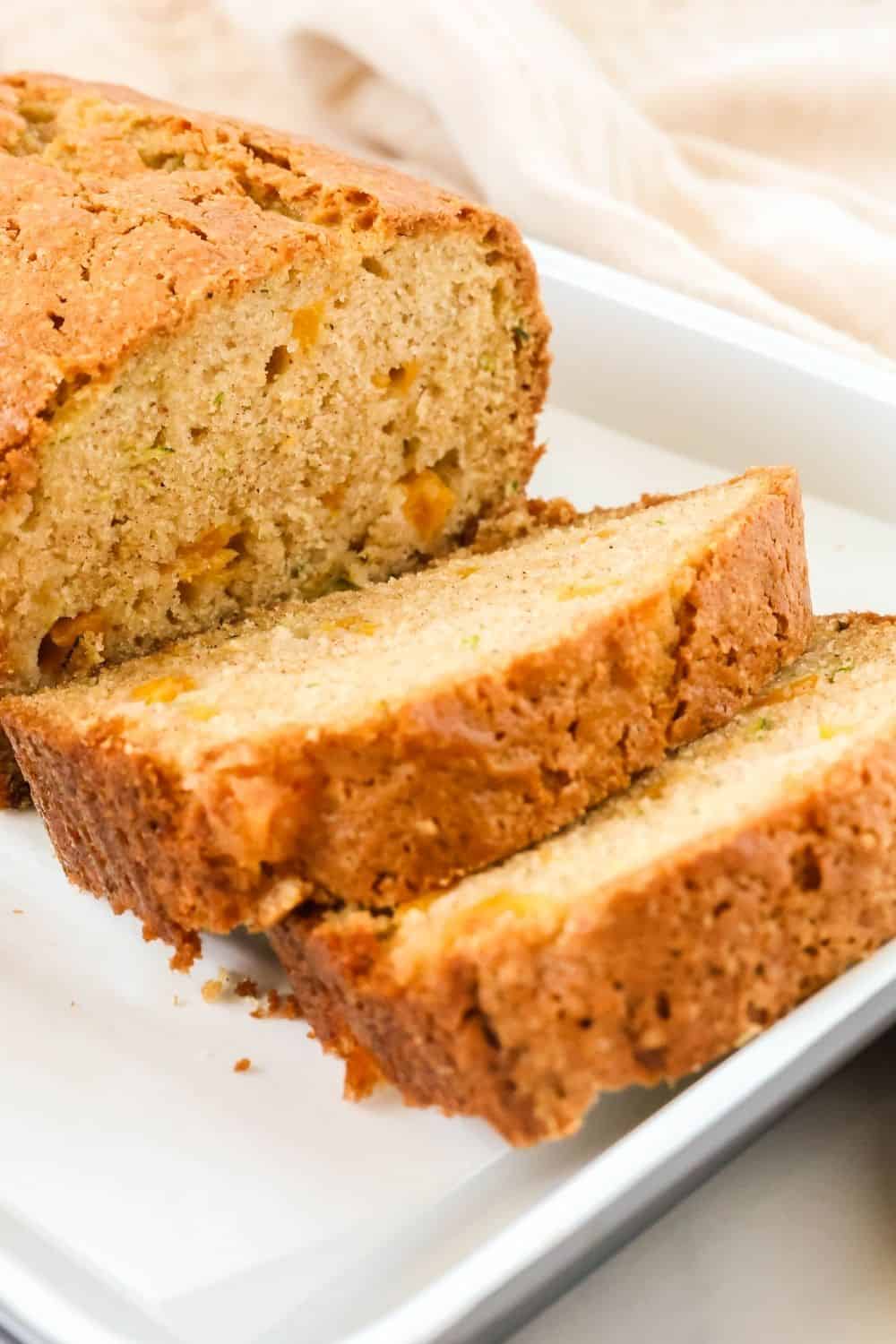 Side view of a sliced loaf of peach and zucchini bread.