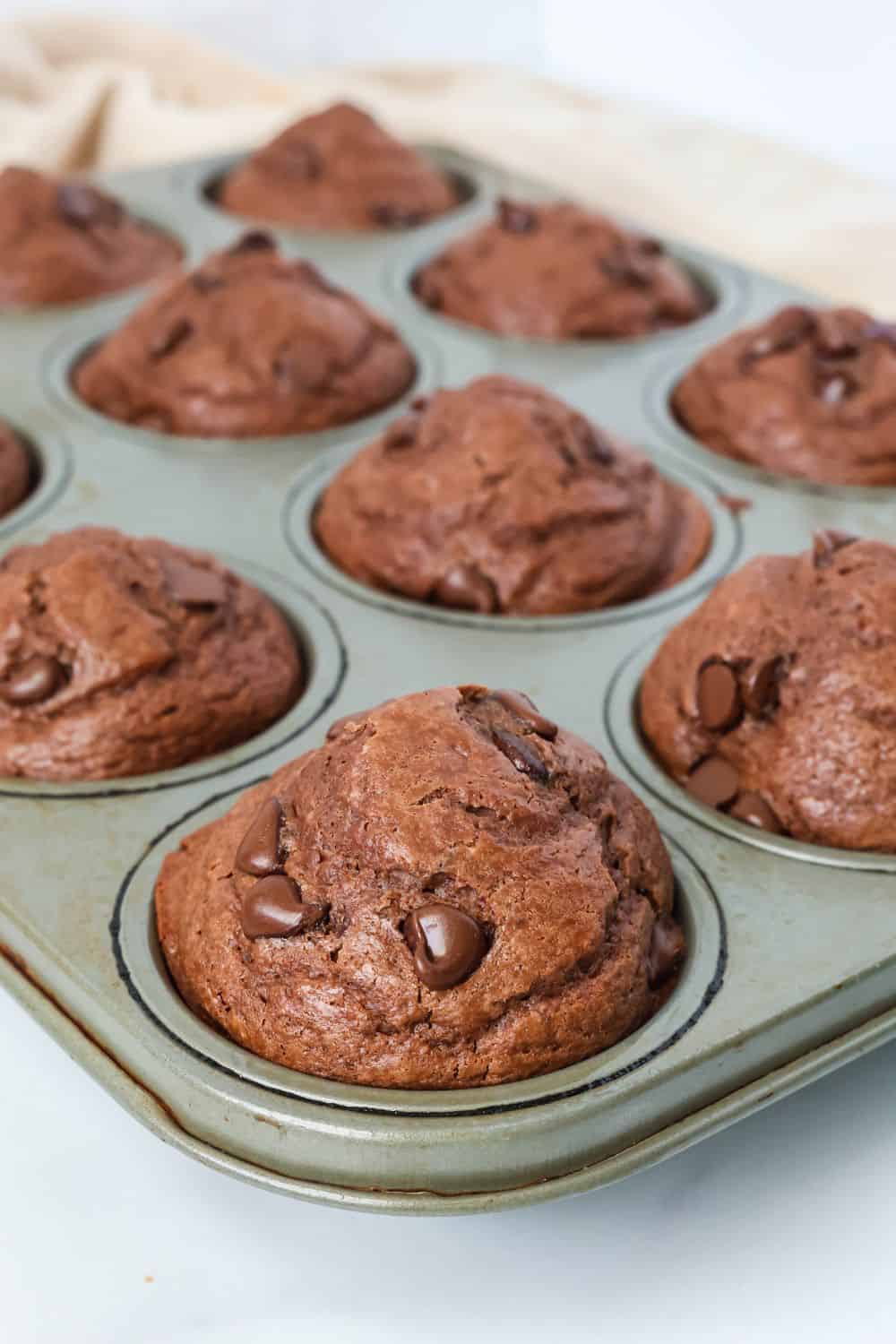 Chocolate Bisquick muffins in a muffin pan.