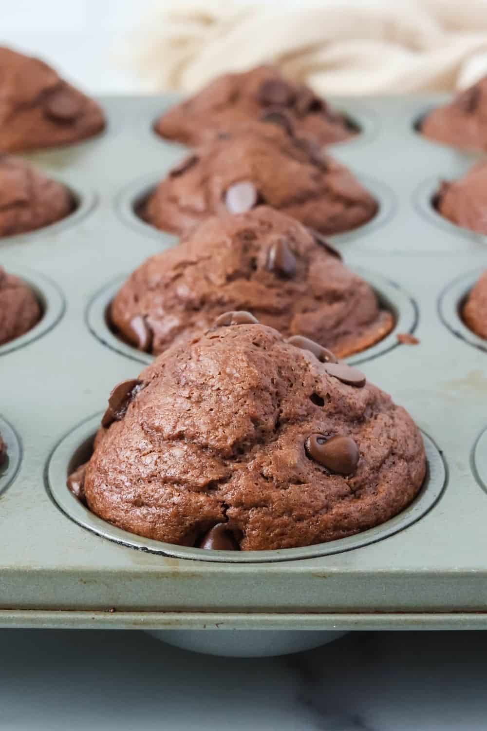close-up view of a muffin pan filled withfreshly-baked double chocolate chip muffins made with Bisquick.