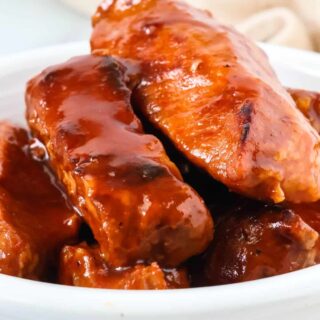 Pressure cooker BBQ country style ribs piled in a white bowl.