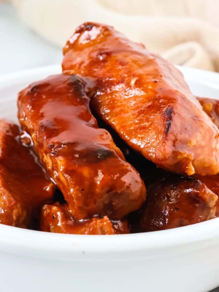 Pressure cooker BBQ country style ribs piled in a white bowl.