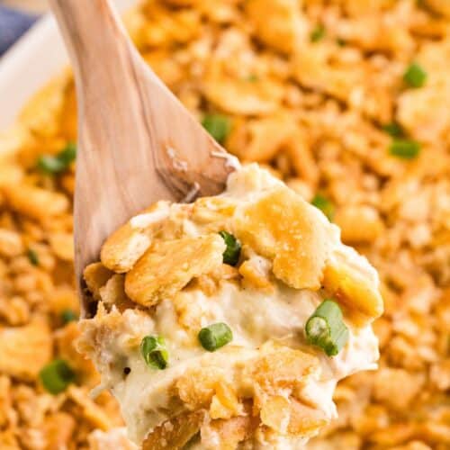 Serving spoon scooping Ritz cracker chicken casserole from the baking dish.