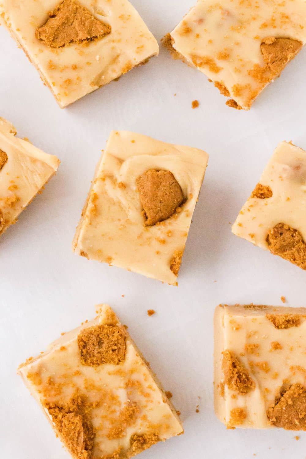 Several squares of Biscoff cookie butter fudge on a white surface.