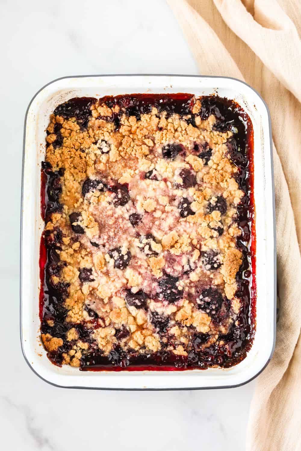 overhead view of a 9x13" pan filled with freshly baked cherry bisquick cobbler made with frozen fruit.