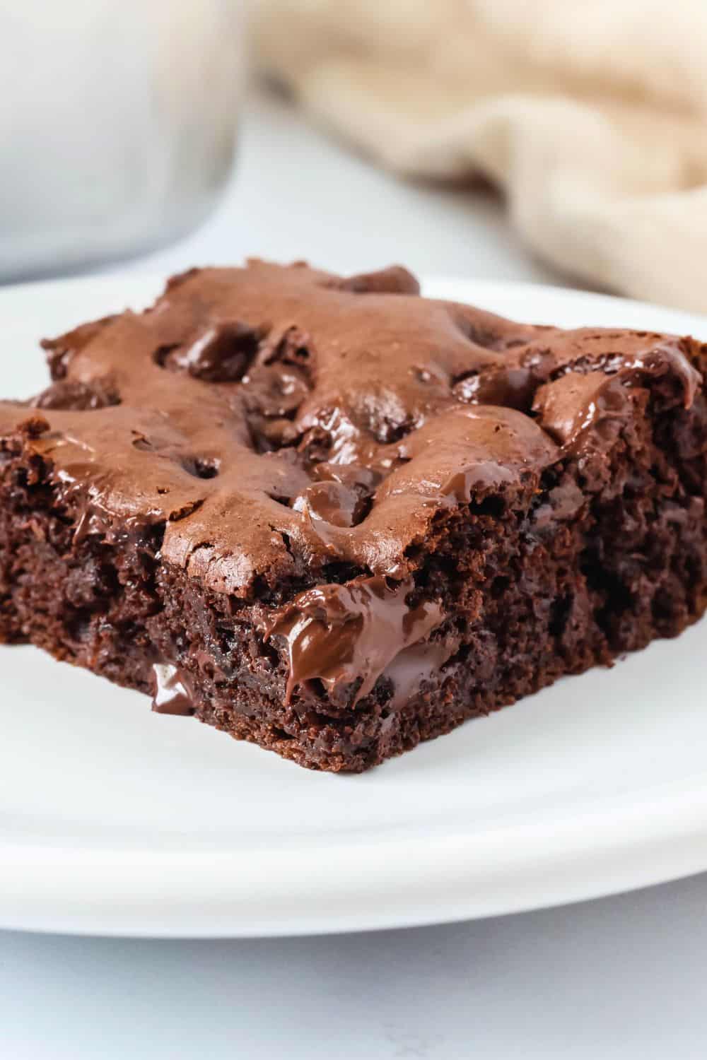 Close-up side view of a slice of chocolate pudding dump cake, showcasing the moist interior of the cake as well as the melty chocolate chips.
