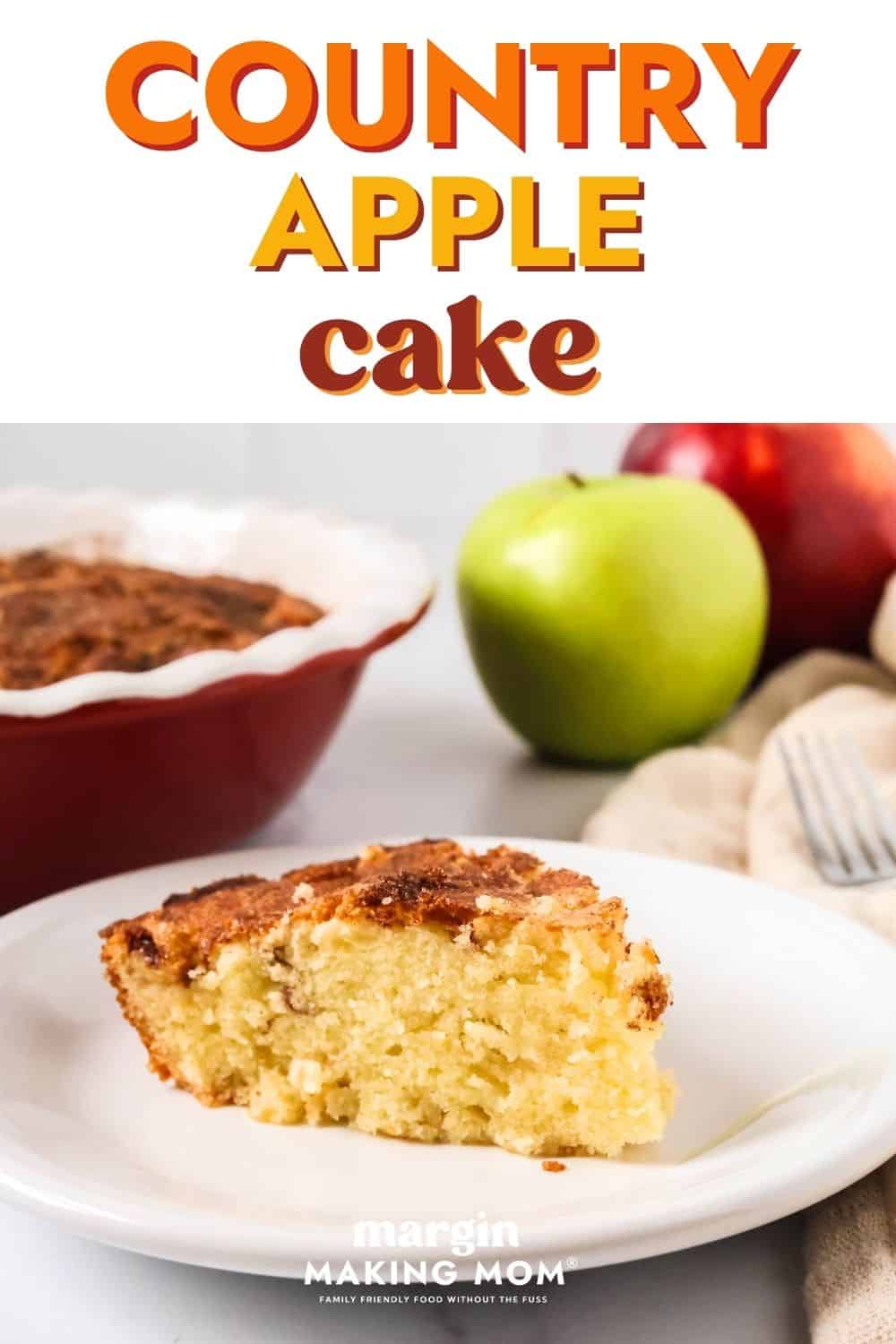 Slice of easy country apple cake served on a white plate. The cake pan and fresh apples are in the background.